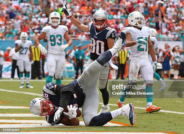 Rob Gronkowski of the New England Patriots scores a second quarter touchdown on a pass from Tom Brady as teammate Danny Amendola celebrates during a...