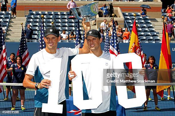 Mike Bryan and Bob Bryan of United States pose with the champions trophy after their 100th career title win after defeating Marcel Granollers and...