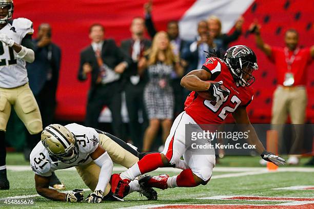 Jacquizz Rodgers of the Atlanta Falcons runs the ball for a touchdown past Jairus Byrd of the New Orleans Saints in the second half at the Georgia...