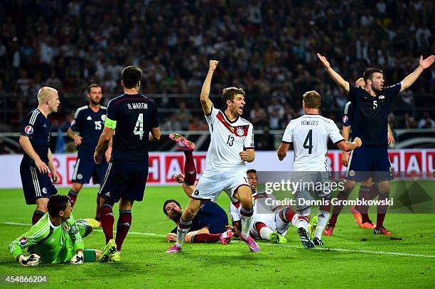 Scotland players react as Thomas Mueller of Germany celebrates scoring their second goal during the EURO 2016 Group D qualifying match between...