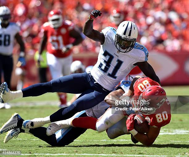 Anthony Fasano of the Kansas City Chiefs is tackled by Michael Griffin and Bernard Pollard of the Tennessee Titans during the second half at...