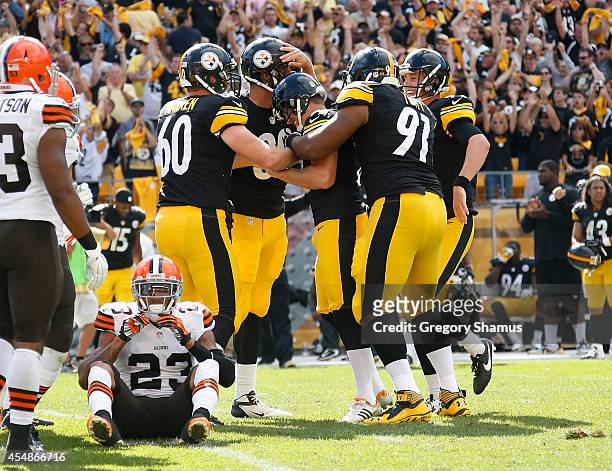 Shaun Suisham of the Pittsburgh Steelers celebrates with teammates after his 41 yard game winning field goal in front of Joe Haden of the Cleveland...
