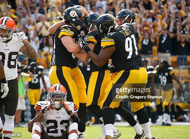 Shaun Suisham of the Pittsburgh Steelers celebrates with teammates after his 41 yard game winning field goal in front of Joe Haden of the Cleveland...
