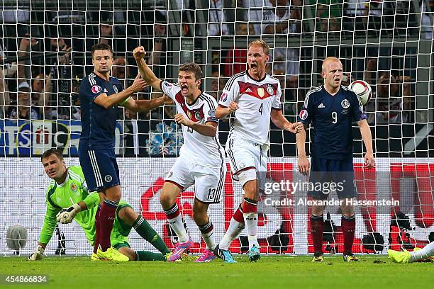 Thomas Mueller of Germany celebrates scoring their second goal with team mates during the EURO 2016 Group D qualifying match between Germany and...