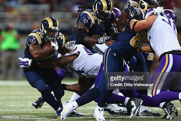 Benjamin Cunningham of the St. Louis Rams is tackled by Jasper Brinkley of the Minnesota Vikings at the Edward Jones Dome on September 7, 2014 in St....