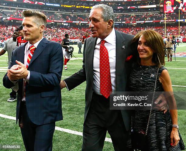 Atlanta Falcons general manager Thomas Dimitroff, team owner Arthur Blank, and Angela Macuga celebrate their 37-34 overtime win over the New Orleans...