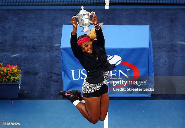 Serena Williams of the United States celebrates with the trophy after defeating Caroline Wozniacki of Denmark to win their women's singles final...