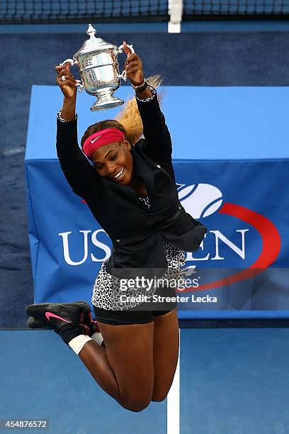 Serena Williams of the United States celebrates with the trophy after defeating Caroline Wozniacki of Denmark to win their women's singles final...