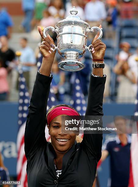 Serena Williams of the United States celebrates with the trophy after defeating Caroline Wozniacki of Denmark to win their women's singles final...