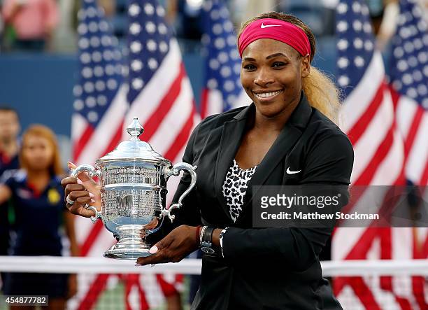 Serena Williams of the United States celebrates with the trophy after defeating Caroline Wozniacki of Denmark to win their women's singles final...