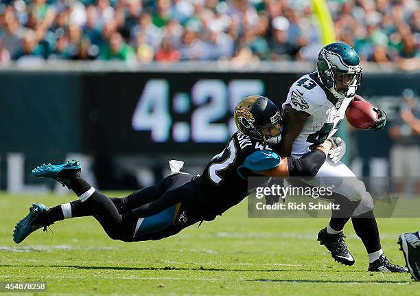 Darren Sproles of the Philadelphia Eagles is grabbed by Chris Prosinski of the Jacksonville Jaguars during the third quarter of a NFL game at Lincoln...