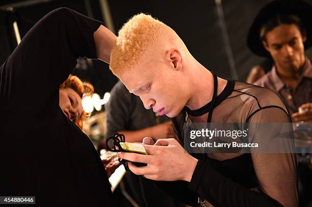 Model Shaun Ross prepares backstage at the Etxeberria fashion show during Mercedes-Benz Fashion Week Spring 2015 at The Pavilion at Lincoln Center on...