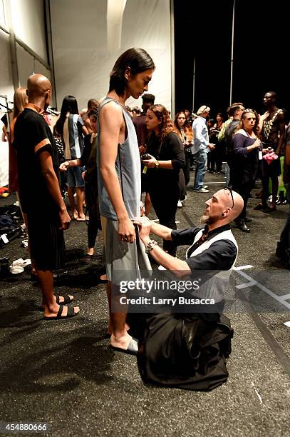 Designer Roberto López Etxeberría prepares a model backstage at the Etxeberria fashion show during Mercedes-Benz Fashion Week Spring 2015 at The...