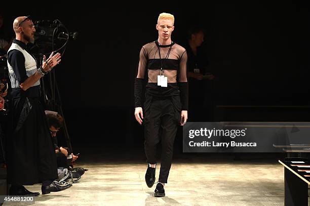 Designer Roberto López Etxeberría watches as model Shaun Ross walks the Etxeberria fashion show during Mercedes-Benz Fashion Week Spring 2015 at The...