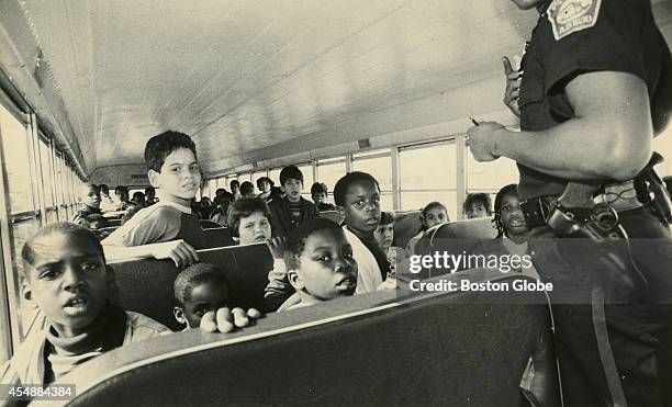 Boston police officer talks with students from Dorchester who were riding the school bus that was stoned at Preble Circle in South Boston on Sept....