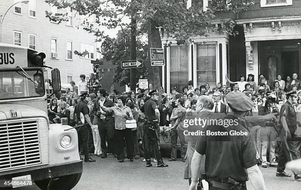 Police hold back a crowd as a school bus drives by in South Boston on Sept. 12 the first day of school under the new busing system put in place to...