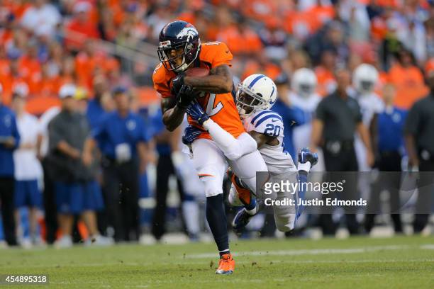 Wide receiver Andre Caldwell of the Denver Broncos is tackled after a reception by free safety Darius Butler of the Indianapolis Colts during a game...