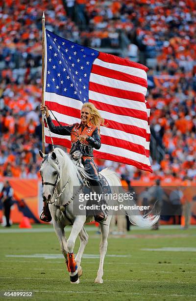 Thunder the Denver Broncos mascot is ridden down the field by Ann Judge-Wegener after the Denver Broncos scores against the Indianapolis Colts at...