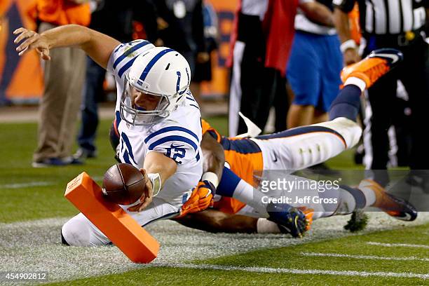 Quarterback Andrew Luck of the Indianapolis Colts reaches across the goal line for a second-quarter touchdown against the Denver Broncos at Sports...
