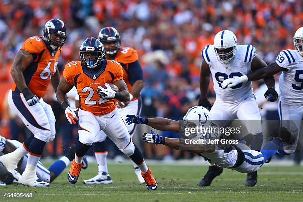 Running back C.J. Anderson of the Denver Broncos rushes as strong safety LaRon Landry of the Indianapolis Colts attempts a tackle during a game at...