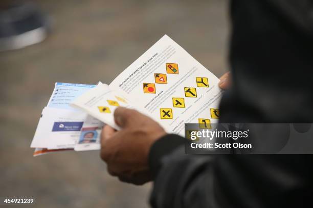 An Illinois resident uses a Spanish-language study guide to prepare for his driver's license exam at a driver services facility on December 10, 2013...