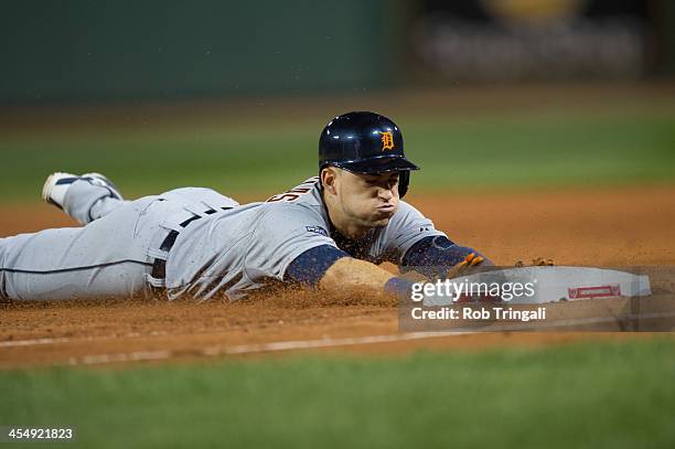 Jose Iglesias of the Detroit Tigers slides safely back to first base during Game Six of the American League Championship Series against the Detroit...