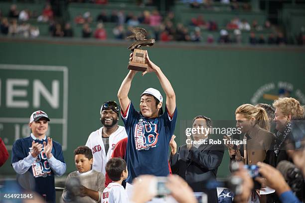 Boston Red Sox relief pitcher Koji Uehara raises the MVP trophy after defeating the Detroit Tigers in Game Six of the American League Championship...