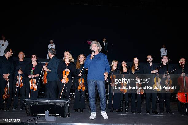Violonist Anne Gravoin , stage director Elie Chouraqui and the orchestra on stage at the end of the 'Claude Lelouch en Musique ! Held at the...