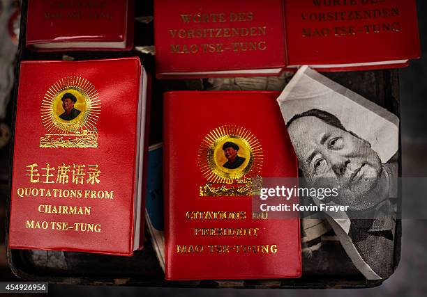 Portrait of the late Chinese leader Mao Zedong is seen next to copies of his famous "Red Book' in various languages for sale at a vendor's stand at a...