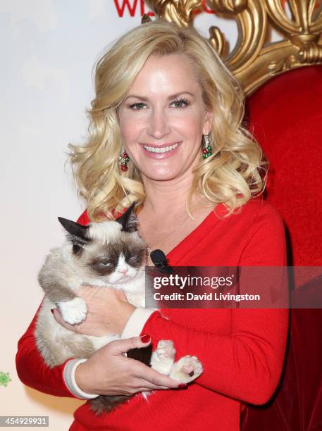 Actress Angela Kinsey poses with Grumpy Cat at the Internet Cat Super Group holiday unveiling event at Capitol Records Tower on December 10, 2013 in...