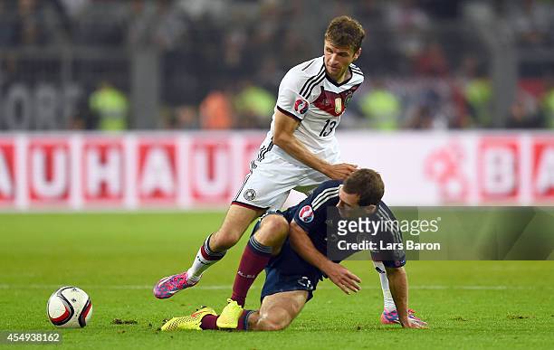 Thomas Mueller of Germany is challenged by James McArthur of Scotland during the EURO 2016 Group D qualifying match between Germany and Scotland at...