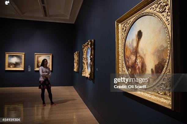 Woman admires the works of art in a new exhibition at the Tate Britain gallery entitled 'Late Turner - Painting Set Free' on September 8, 2014 in...