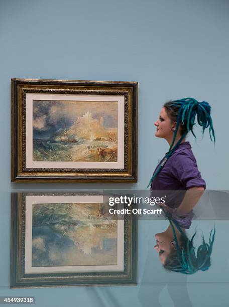 Woman views a painting by J.M.W. Turner entitled 'Bamborough Castle' in a new exhibition at the Tate Britain gallery entitled 'Late Turner - Painting...