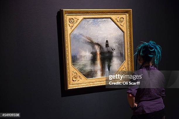 Woman views a painting by J.M.W. Turner entitled 'Peace - Burial at Sea' in a new exhibition at the Tate Britain gallery entitled 'Late Turner -...