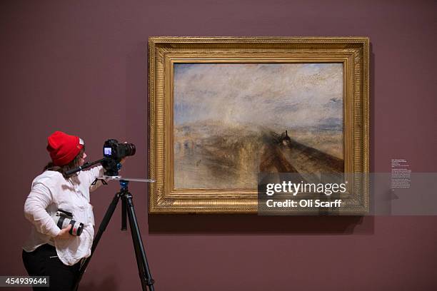 Woman films a painting by J.M.W. Turner entitled 'Rain, Steam and Speed - the Great Western Railway' in a new exhibition at the Tate Britain gallery...