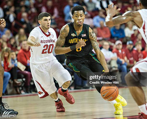 JaMichael Hawkins of the SE Louisiana Lions drives to the basket past Kikko Haydar of the Arkansas Razorbacks at Bud Walton Arena on December 3, 2013...