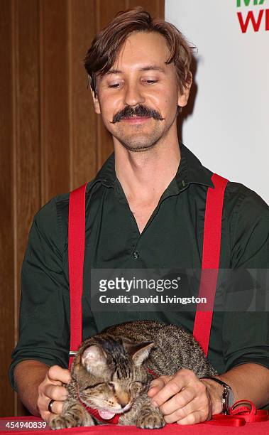 Owner Mick Szydlowski poses with his blind cat Oskar at the Internet Cat Super Group holiday unveiling event at Capitol Records Tower on December 10,...