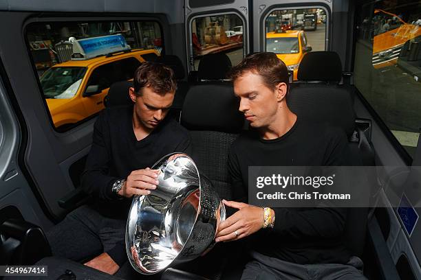 Bob Bryan and Mike Bryan of United States look at the US Open men's doubles champions trophy during their New York City media tour after winning...