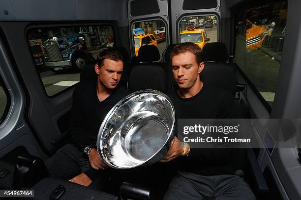 Bob Bryan and Mike Bryan of United States look at the US Open men's doubles champions trophy during their New York City media tour after winning...