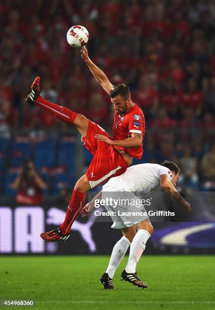 Haris Seferovic of Switzerland jumps over Phil Jones of England during the UEFA EURO 2016 Group E qualifying match between Switzerland and England at...
