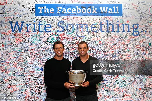 Bob Bryan and Mike Bryan of United States pose with the US Open men's doubles champions trophy at the offices of Facebook during their New York City...