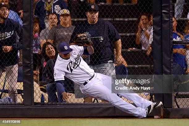 Rymer Liriano of the San Diego Padres hits the wall as he makes the catch on a ball hit by Dee Gordon of the Los Angeles Dodgers during the game at...