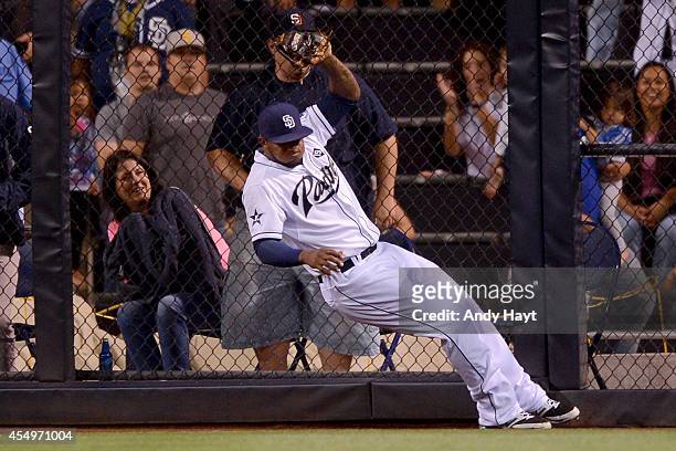 Rymer Liriano of the San Diego Padres hits the wall as he makes the catch on a ball hit by Dee Gordon of the Los Angeles Dodgers during the game at...