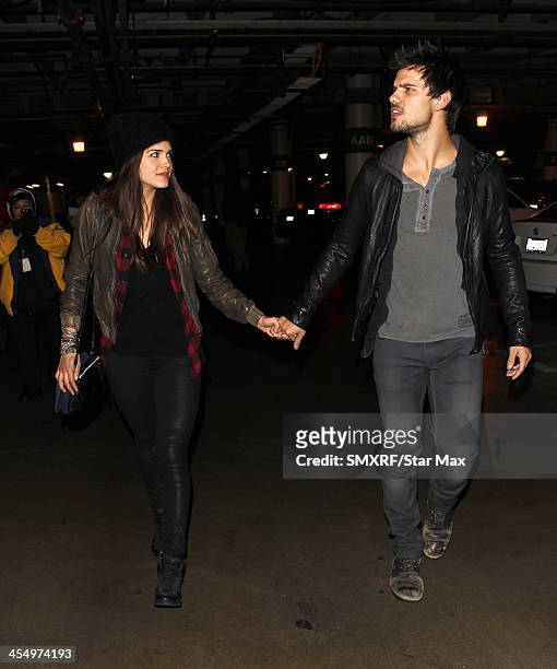 Actor Taylor Lautner and Marie Avgeropoulos are seen on December 09, 2013 in Los Angeles, California.