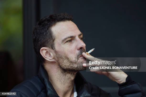 French rogue trader of the Societe Generale bank, Jerome Kerviel, smokes a cigarette on September 8, 2014 at a cafe terrace in Paris, after he left...