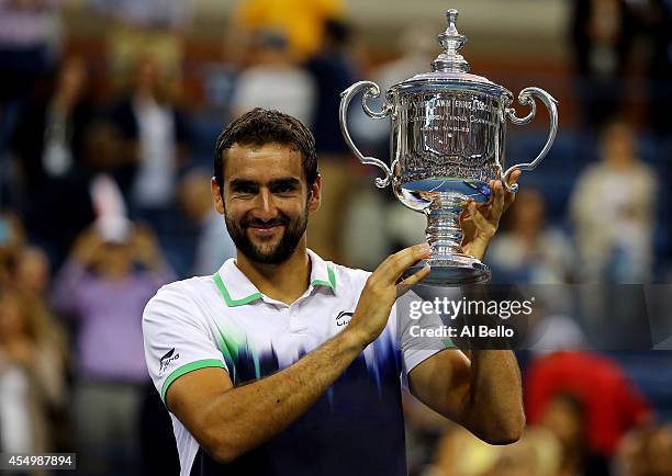 Marin Cilic of Croatia celebrates with the trophy after defeating Kei Nishikori of Japan to win the men's singles final match on Day fifteen of the...