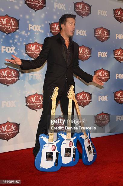 Singer Luke Bryan poses with his awards for Artist Of The Year, Male Artist Of The Year and Touring Artist Of The Year in the press room during the...