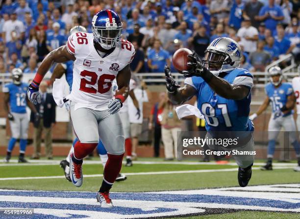 Calvin Johnson of the Detroit Lions catches a first quarter touchdown next to Antrel Rolle of the New York Giants at Ford Field on September 8, 2014...