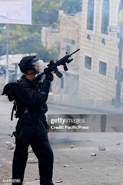 An Israeli soldier points his M-16 at a nearby house on the street in Al-Wadi Joz, in eastern Jerusalem. A firecraker had been fired minutes before...