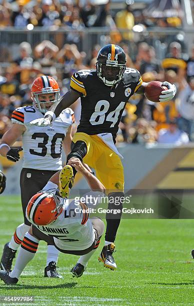 Punt returner Antonio Brown of the Pittsburgh Steelers attempts to hurdle punter Spencer Lanning of the Cleveland Browns as Jim Leonhard looks on...
